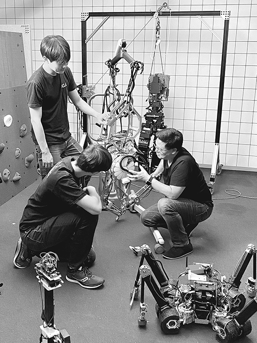 PhD students Min Sung Ahn and Kyle Gillespie with professor Dennis W. Hong with humanoid robot